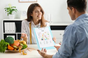 Dietitian consulting patient at table in clinic